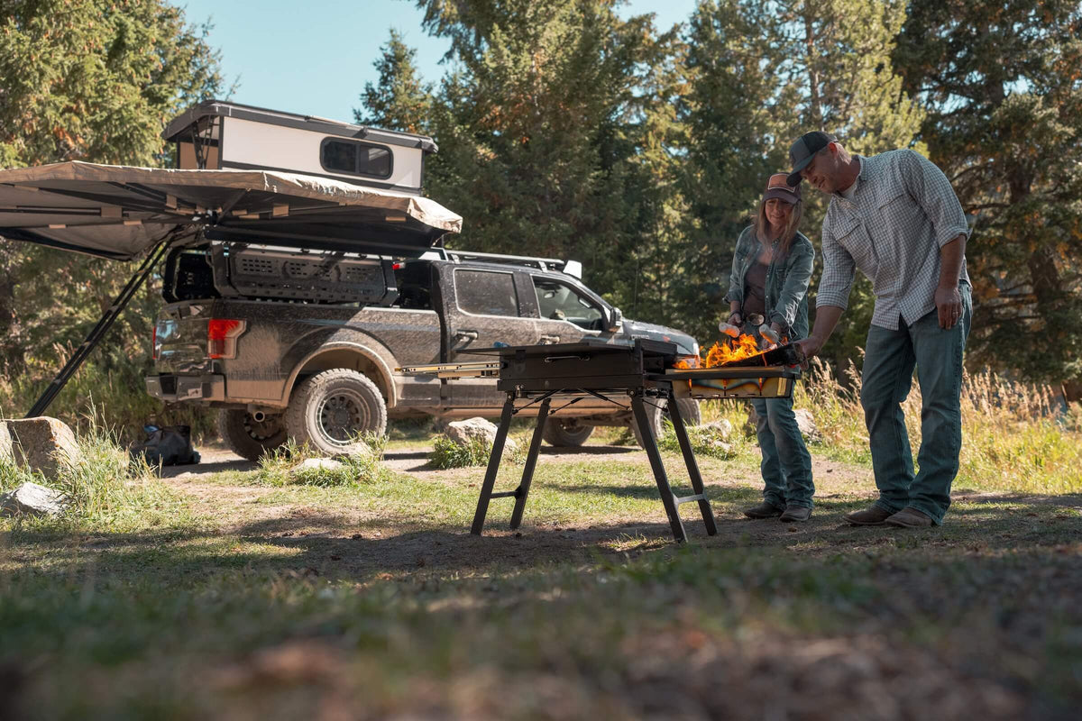 Mohab PROVIS grill and table at the tailgate of a truck-camper setup